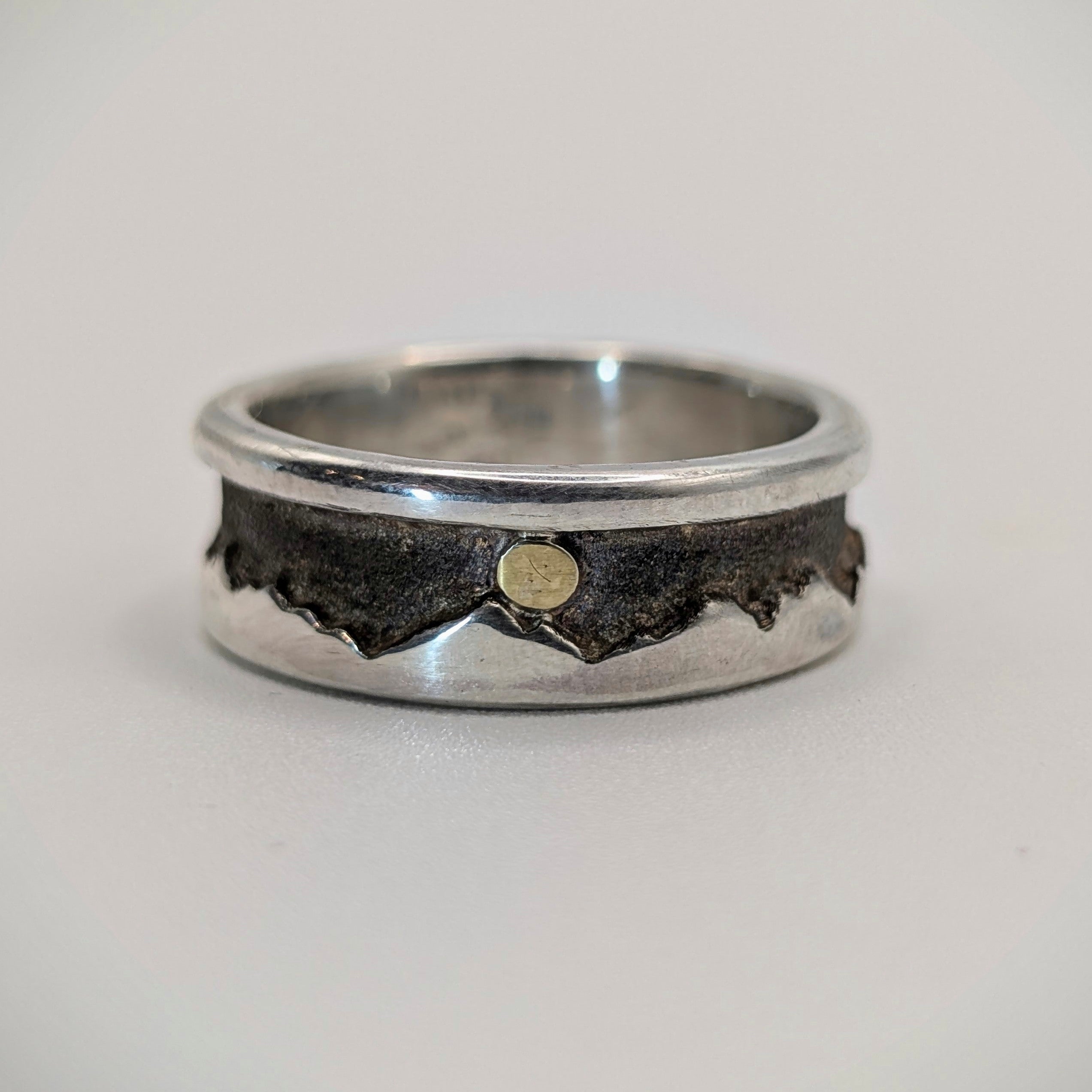 Sterling Silver with gold nugget sun ring with a textured design on a light gray background.
