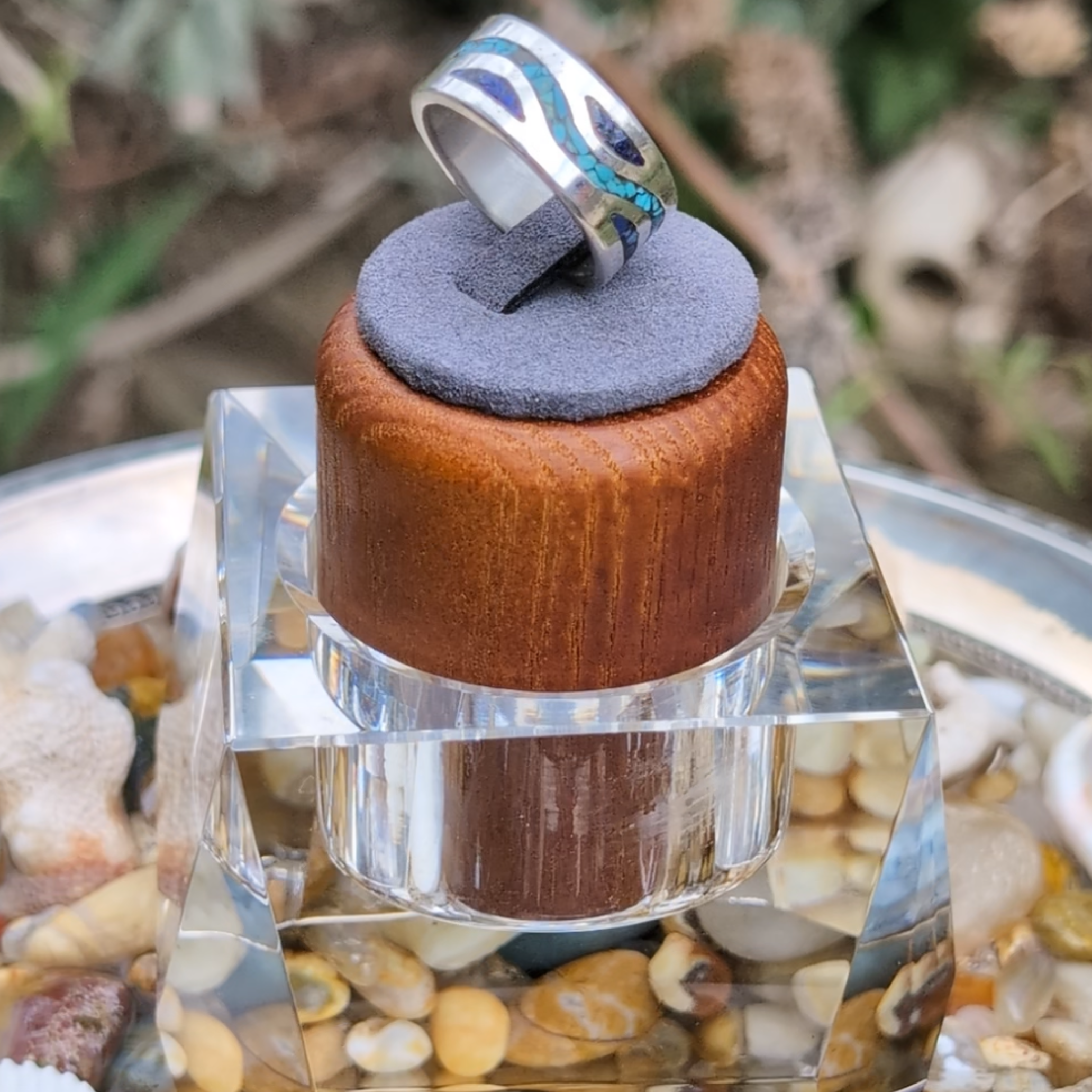Ring on a wooden and glass stand with a natural background