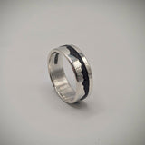Silver ring with a black interior on a gray background