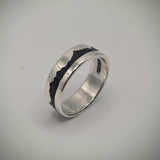 Silver ring with black interior on a light gray background