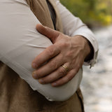 Person wearing a beige jacket with a blurred natural background