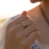 Close-up of a hand with a gold ring on a blurred background
