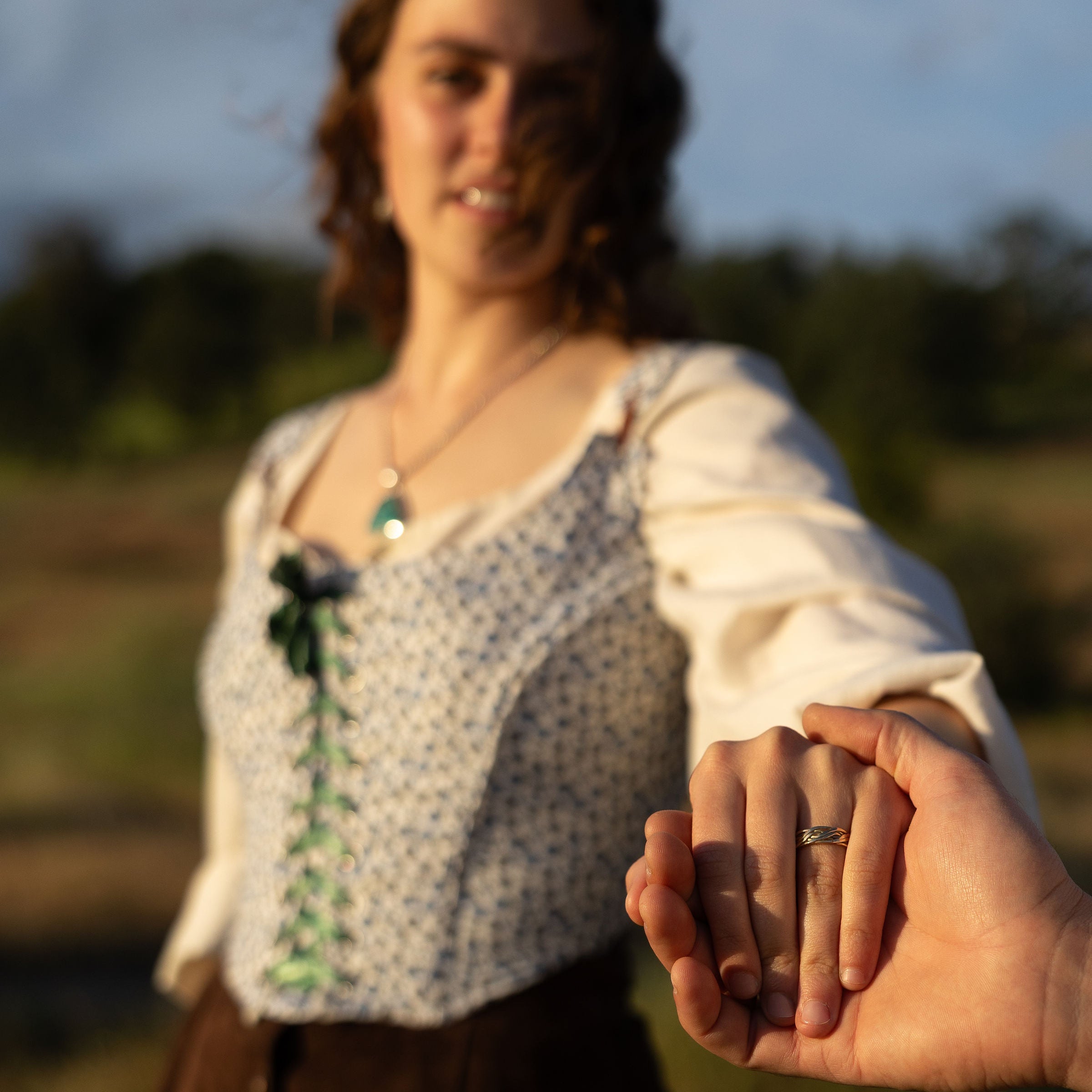 Person holding hands with another person in a natural setting
