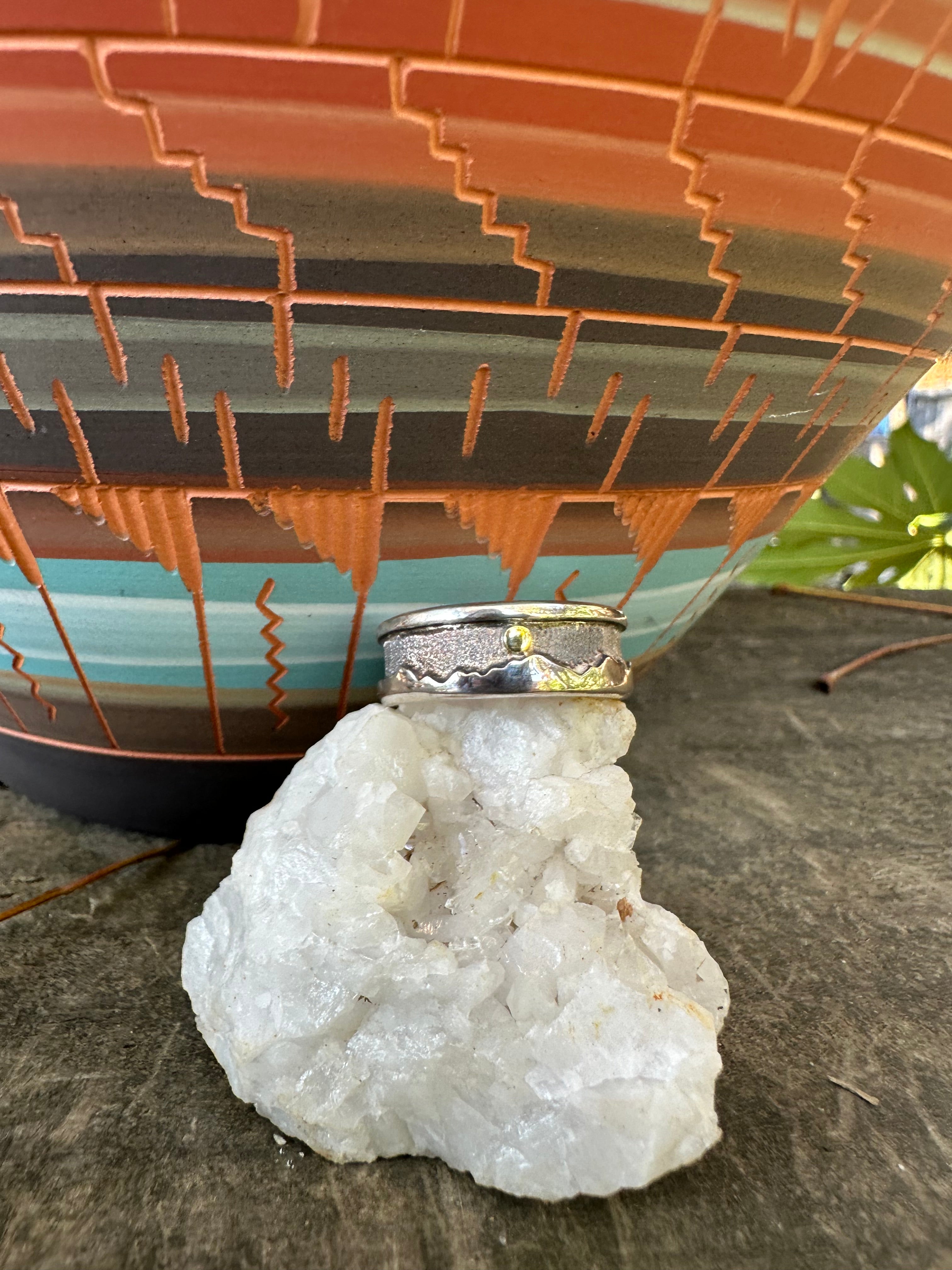 Close-up of a ring on a crystal on a textured surface with a blurred background