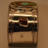 Silver cuff with a turquoise stone on a white background