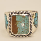 A silver ring featuring a square bezel set with a split center design of brown and turquoise, flanked by small turquoise inlays on a cream background.
