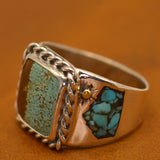 A silver-toned ring with a large square turquoise stone on one side and a smaller inlaid turquoise section on the other, set against a warm brown background.