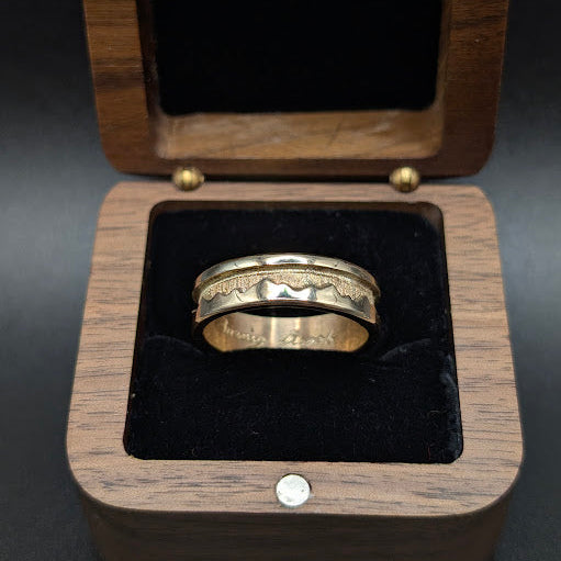 Gold ring in a wooden box with black interior